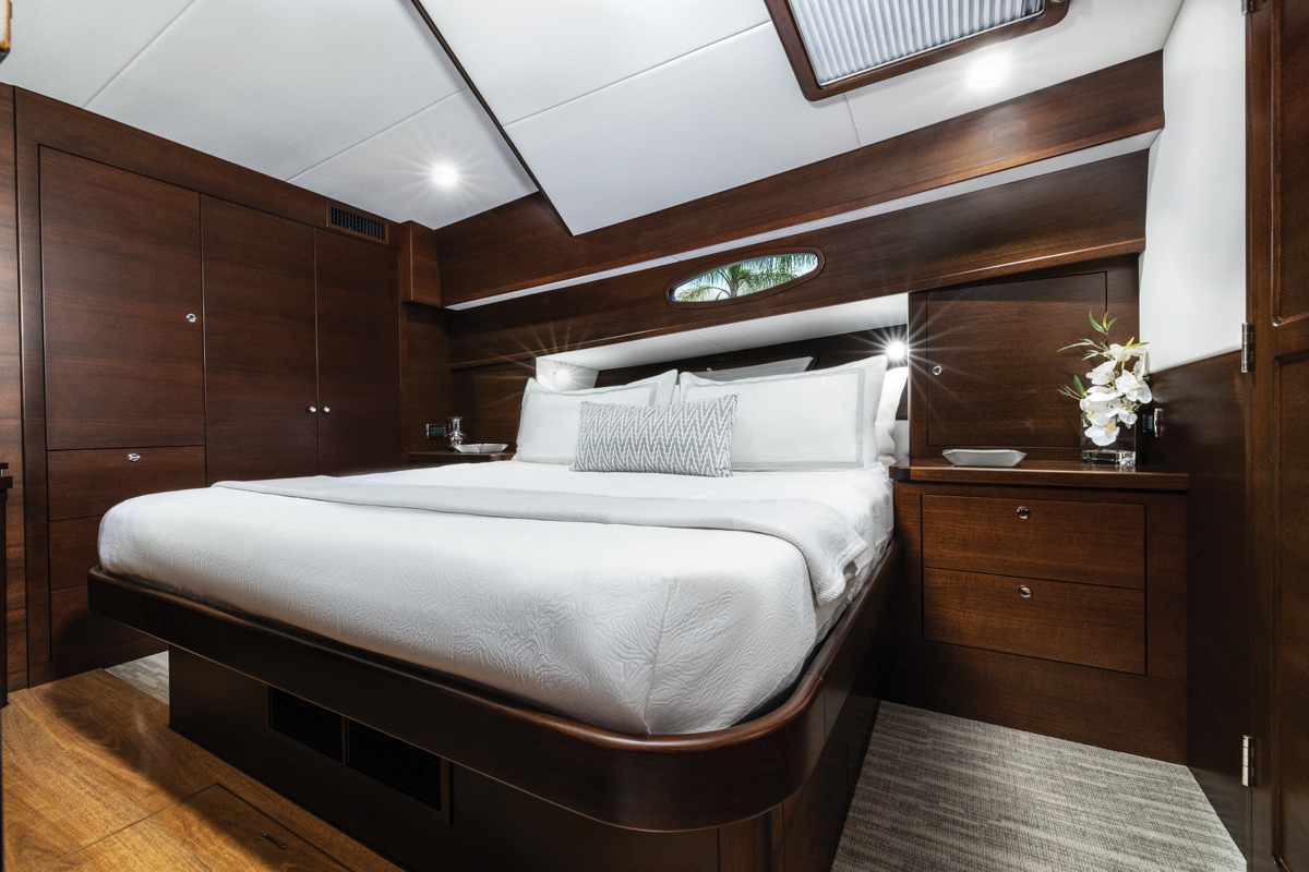 A suíte principal, no meio-navio, com cama king e revestimento em madeira escura. Foto: Cortesia Grand Banks