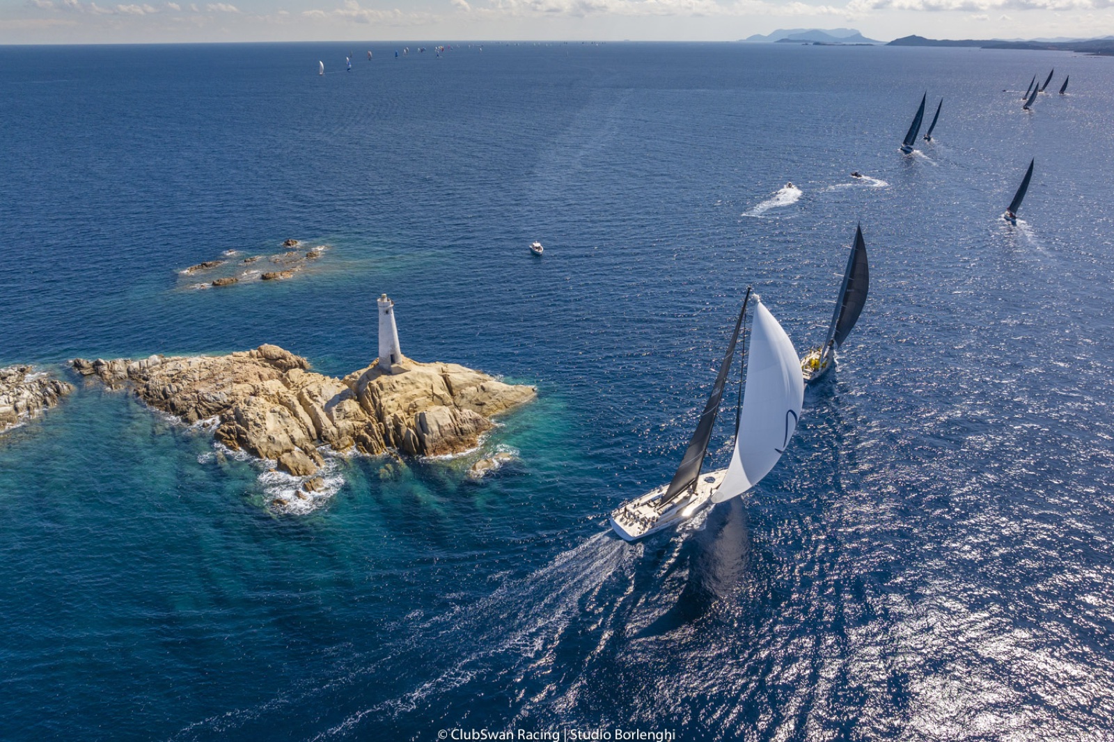 Um veleiro Swan contornando o farol de um ilhéu rochoso na Sardenha. Foto: Studio Borlenghi / ClubSwan Racing